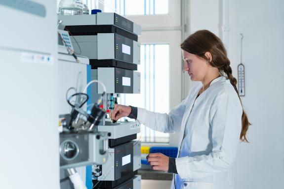 Eine Wissenschaftlerin an einem Messgerät im Labor
