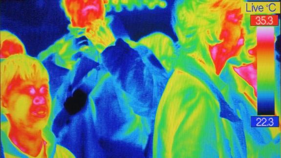 Infrarot-Bild von drei Menschen, auf dem bunte Farben die Wärmeverteilung anzeigen