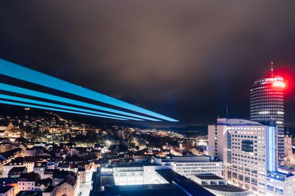 Blick auf Jena bei der Langen Nacht der Wissenschaften Jena 2026, nächtlicher Abendhimmel mit Skyline und blauen Lasern