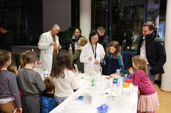 Forschende experimentieren mit Kindern.