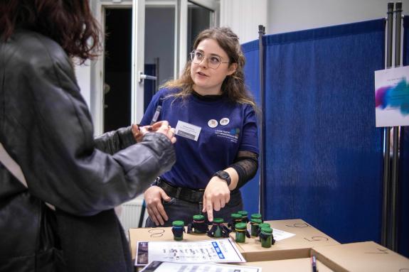 M.Sc. Vanessa Nöring, wissenschaftliche Mitarbeiterin am Lehrstuhl für Klinische Psychologie, wertet gemeinsam mit Besucher:innen das Mitmachangebot „Multimodales Memory“ aus. Dabei werden Gerüche mit ertasteten Gegenständen kombiniert.
