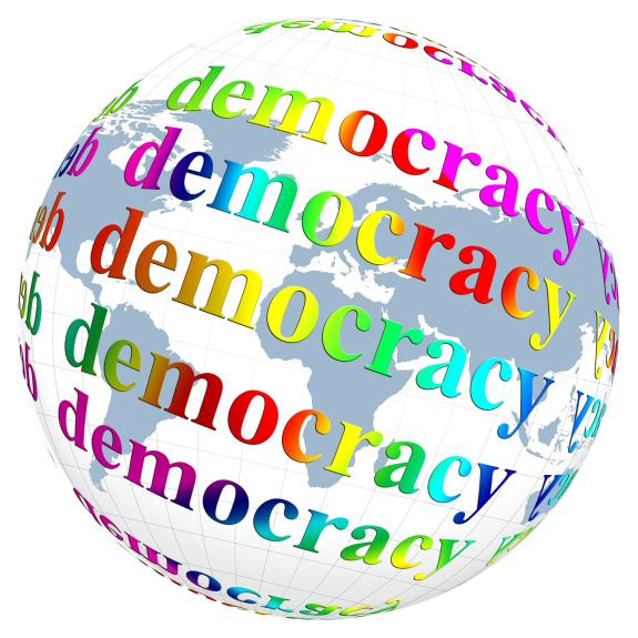 Schwarz-weiße Weltkugel, über die mehrfach "democracy" in regenbogenfarben steht.