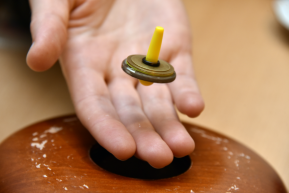Demonstration eines freischwebenden Magnetkreisels über einer Hand.