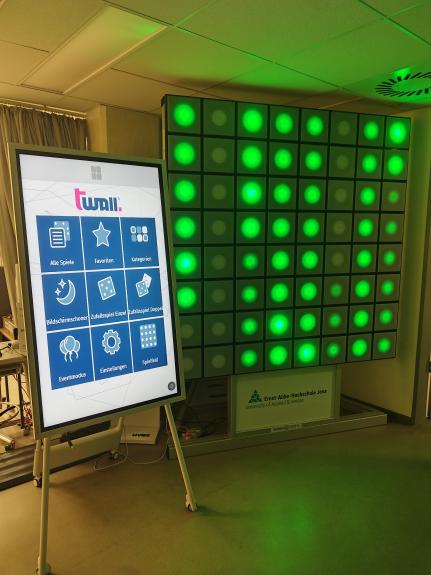 in einem Raum steht ein quadratisches Display mit grün leuchtenden Flächen
