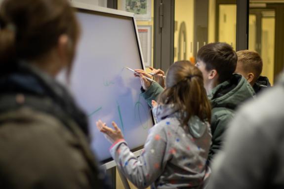 Junge Menschen interagieren mit einem Multimedia Board